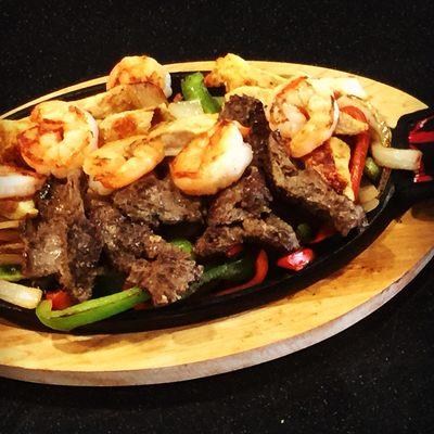 El Presidente Dinner Fajitas. Steak, Shrimp, and Chicken served over sizzling peppers and onions. Tortillas, rice, and beans on the side.