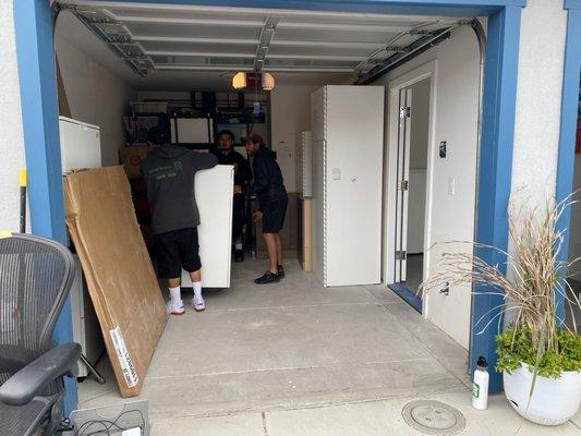 Teamwork moving heavy cabinet with sliding doors.