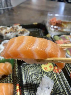 Salmon sushi combo. A big mouthful of salmon .