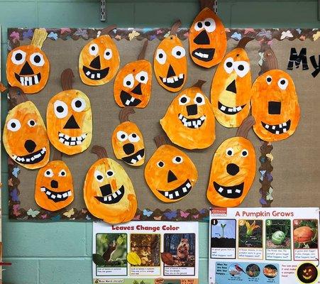 Halloween bulletin board of child-made jack-o-lanterns and information regarding the fall curriculum.