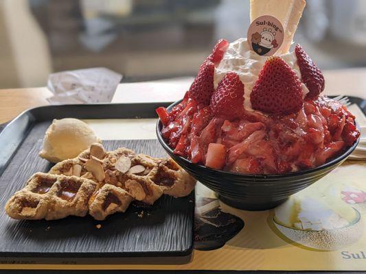 Injeolmi & honey drizzled croffle with vanilla ice cream & premium strawberry topped with a cheesecake.