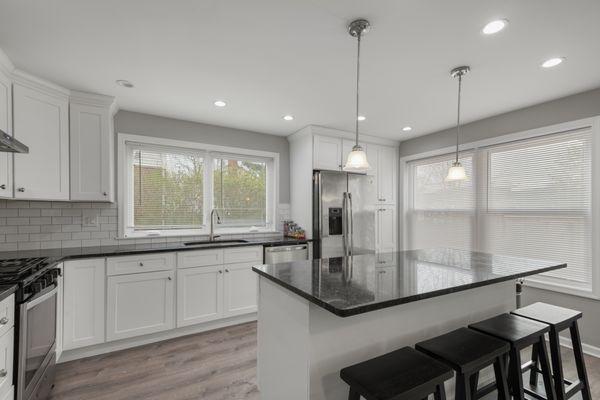 Kitchen remodel. White shaker cabinets. White subway tile backsplash. Granite countertop. Large island with seating. Philadelphia, PA.