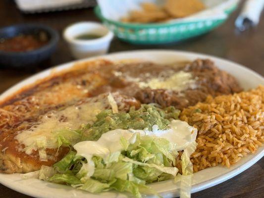 Enchilada and chile relleno combination plate with rice and beans.