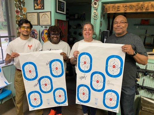 At the range, proudly displaying targets after taking Beginner Handgun Class!