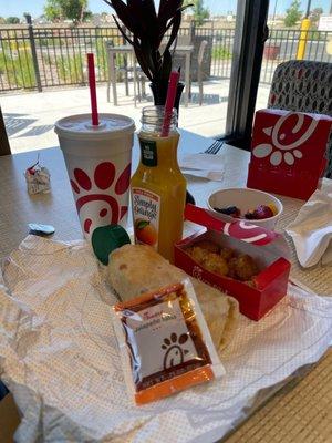 Breakfast burrito with OJ, Fruit, and Hashbrowns