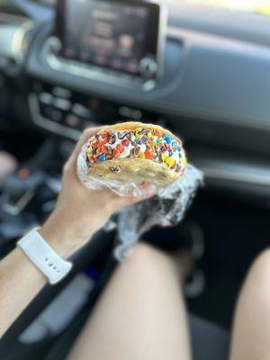 Ice cream cookie sandwich rolled in M&Ms