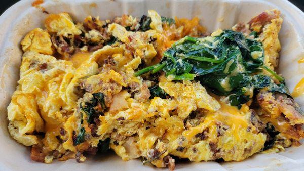 Breakfast bowl with eggs, bacon, chorizo, spinach, and cheddar cheese