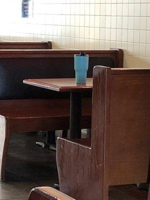 Employee reserving table with her cup.  why?