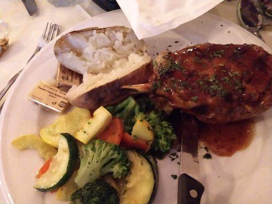 Grilled pork chop, mixed vegetables and baked potato.