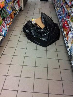 BIG BAGS OF TRASH do not belong right in the middle of aisles forcing customers to step over them.