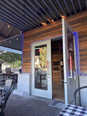 Entrance on the corner, shaded patio.