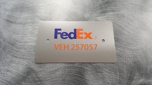 Metal business card with customized holes for attaching to delivery vehicle.