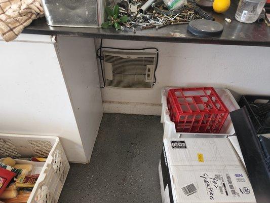 swamp cooler unit under bench inside the garage