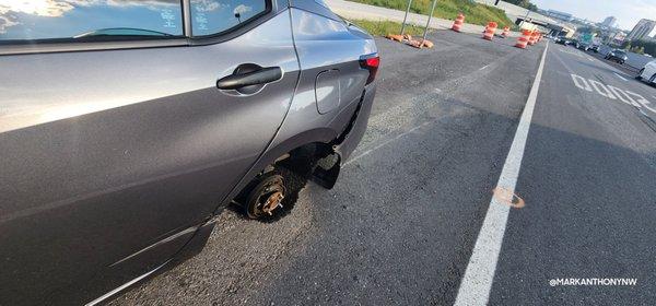 The rear left tire detached from the car in the middle of the highway.