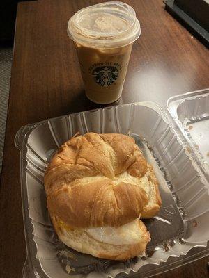 Croissant breakfast sandwich with turkey sausage, egg, and cheddar, and an iced coffee with cream