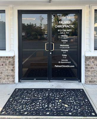 Front door with schedule of office hours for Palmer Chiropractic