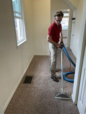 The owner, Jason Young, cleaning the carpet in the hallway of my rental house.