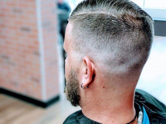 Skin fade with part, styled with Louis XIV pomade.