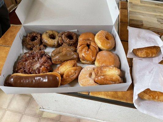 A selection of delicious and fresh donuts, and two croissant sandwiches.