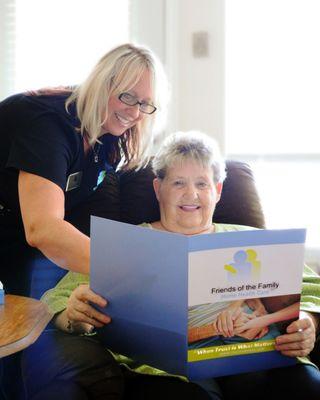 Caregiver reading to a senior.