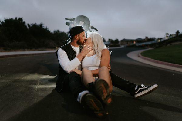 Huntington Beach, California Couples photo session with motorcycle kissing in front of headlight.