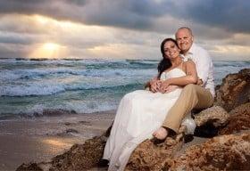 Amazing sunset picture of bride and groom on rocks at Anna Maria Beach House Restaurant.