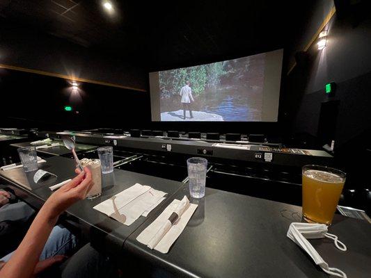 A view of the slide-out tables and the screen. Some seats have less room than others so pay attention to the seating chart on their site.