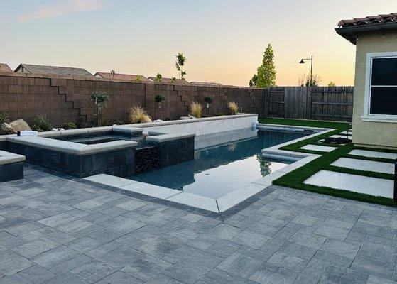 Avalon Slate pavers in Riviera color with Graphite border. The turf is AZ Platinum Spring. Back Yard in Folsom, CA.