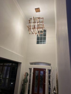 New chandelier installation in two story foyer