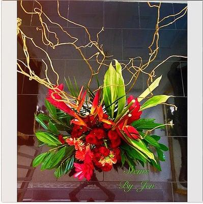 This tropical Oasis features Birds of Paradise, Heliconia, Red Gingers, Palm foliage, & Curly Willow. Perfect for Florida home décor.