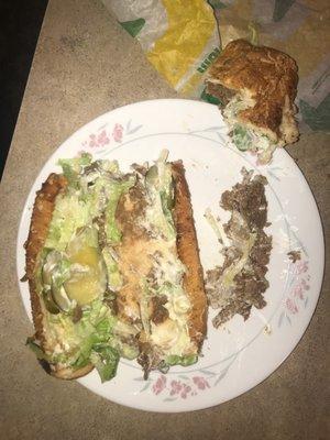 Completed ingredients on six inch of footlong Steak and Cheese Sub