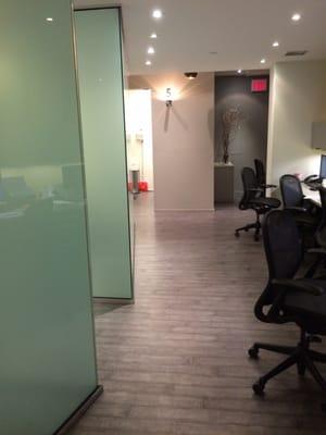 Hallway to patient rooms. Notice rooms are frosted glass for plenty of privacy.