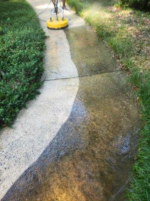 Pressure cleaning a sidewalk, demonstrating our dedication to maintaining clean and safe walkways.