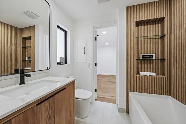 This breathtaking bathroom renovation showcases our Hudson vanities paired with Soho Mirrors.