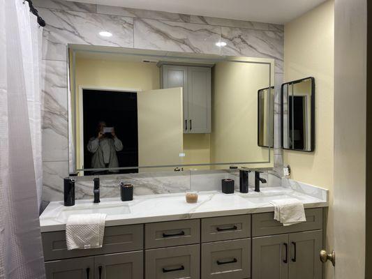 Grey Shaker Vanity Cabinetry with Dual undermount sinks and Frameless Shower Enclosure.