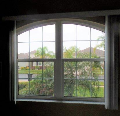 Vertical Blinds shown in open position over arched window.