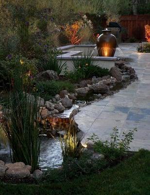 This water feature and planting give this  very long and narrow garden unique visuals.