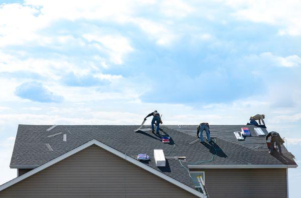 Crews asphalt shingle re-roof in progress.