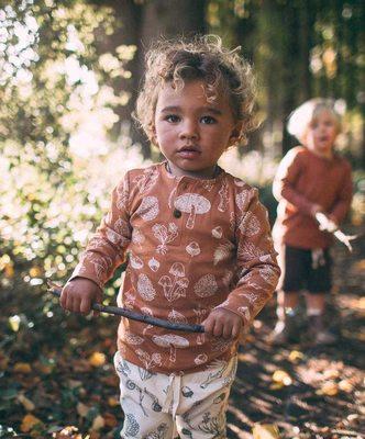 Kids playing wearing the Autumn forest tee. A soft long sleeve organic cotton tee from Ziwi Baby