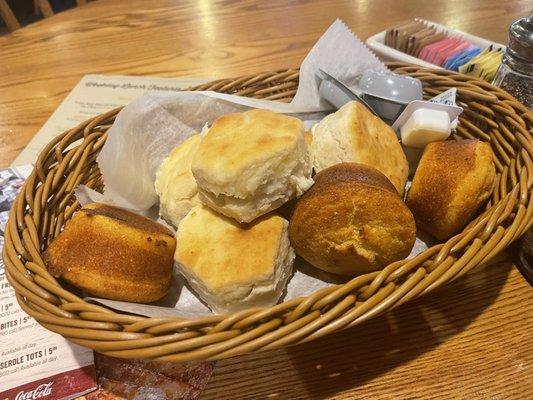 Basket of fresh biscuits and corn bread with butter and apple butter