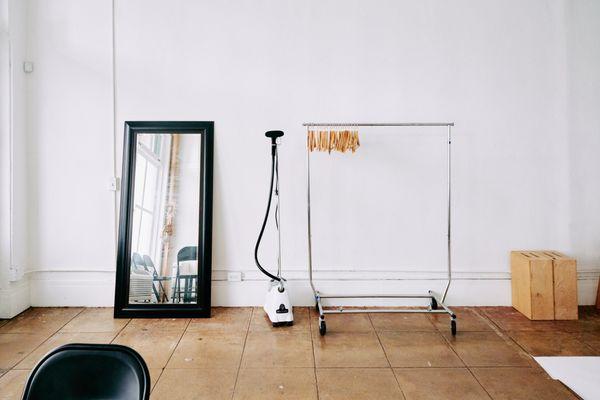 A thoughtfully arranged space at Pauahi Street Photo Studio, featuring a mirror, steamer, and clothing rack--perfect for fashion and styling