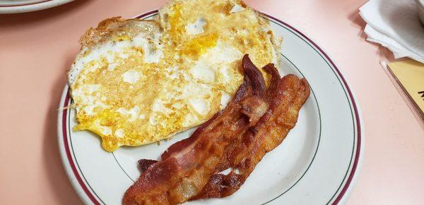 Thin bacon and eggs fried hard