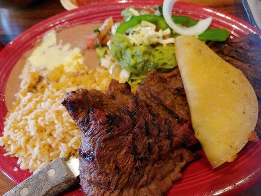 Carne Asada, beans, rice, and guacamole salad.