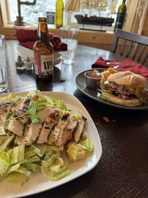 Caesar salad with grilled chicken, and cheeseburger with fries