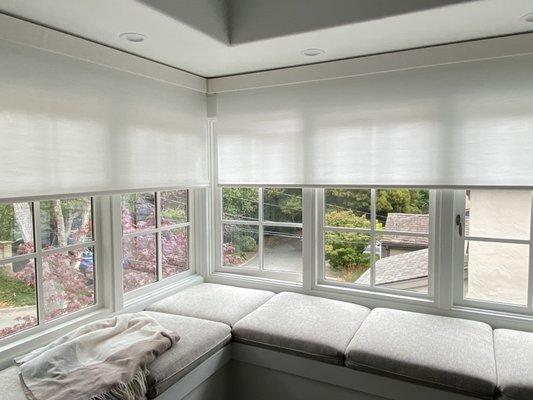 2 Motorize roller shades meeting at the corner of these 2 windows. Filter the light but gives privacy to this cozy master bed room.