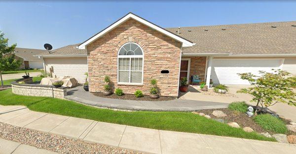 Front patio with pathway, seating wall, accent boulder bed with ornamental tree.