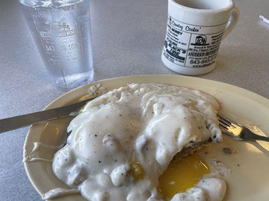 The Barnyard Benedict - open biscuits with sausage patty over medium eggs SMOTHERED in gravy