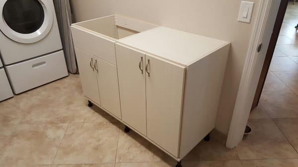 Sink base cabinet with adjustable shelves in right cabinet.