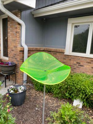 A greenish yellow garden decoration.  These look as if they are illuminating when it's sunny.