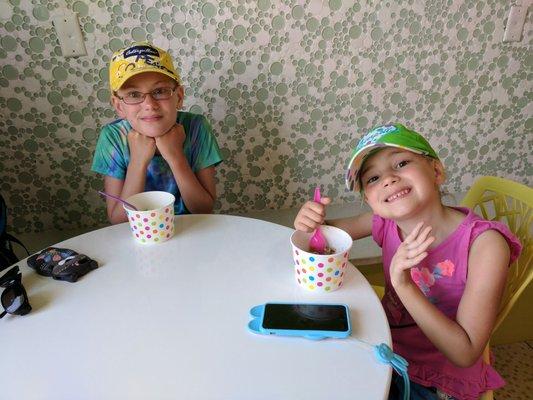 Girls enjoying their small yogurt in a giant sized bowl